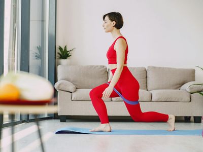 Legs of a man doing lunges in a bright room