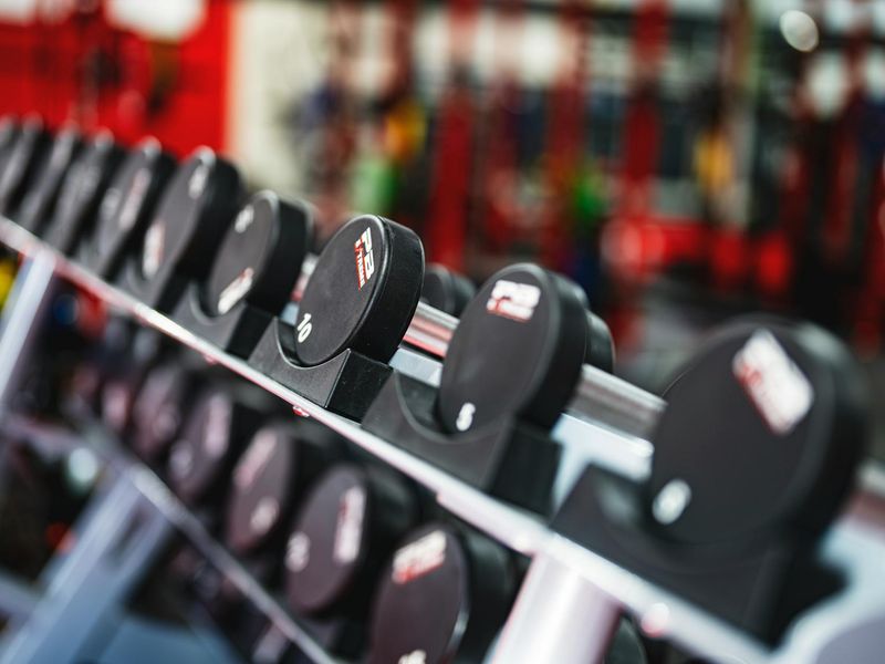 Modern minimalist gym interior with weight benches and dumbbells